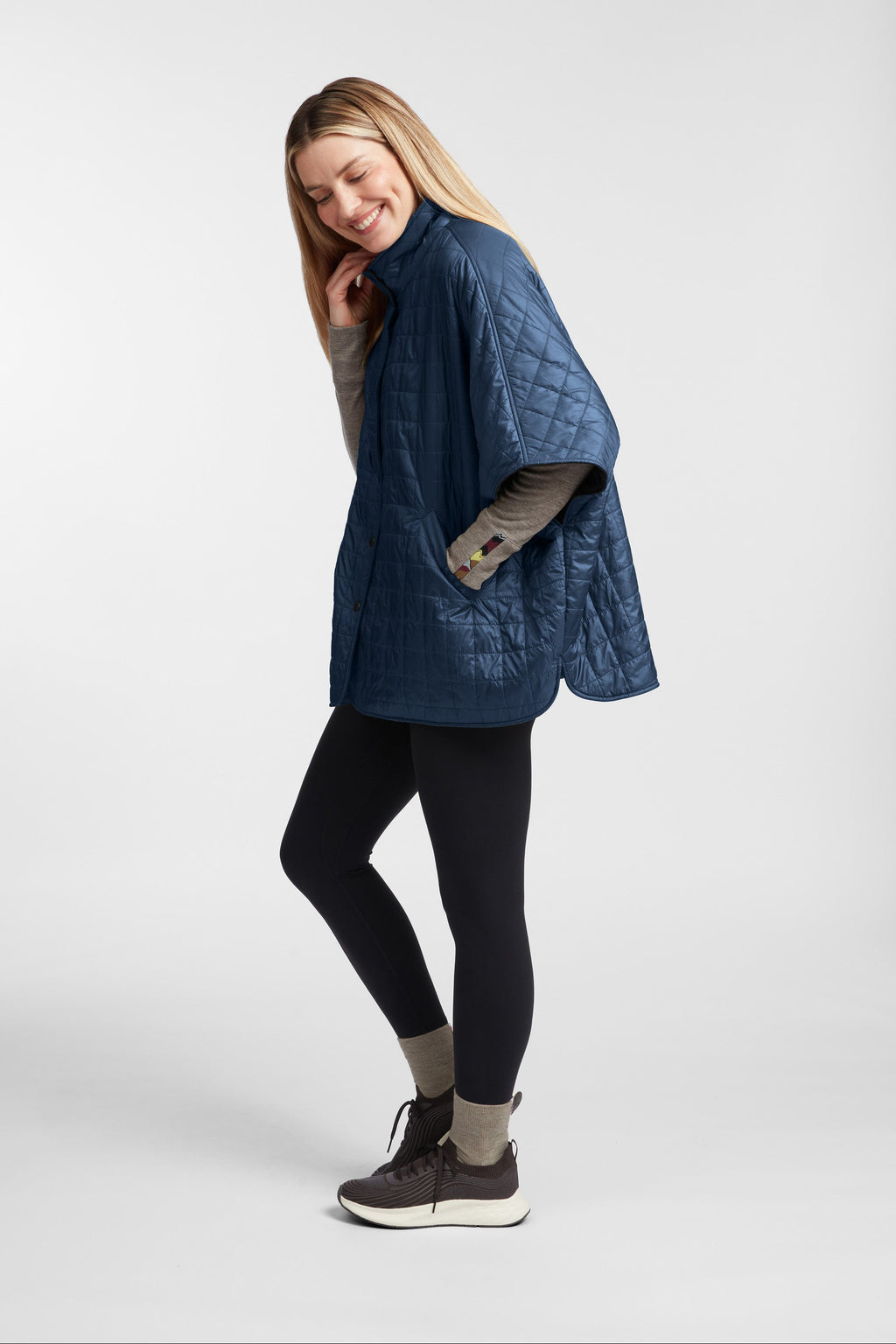 Woman wearing a blue quilted jacket on a white background