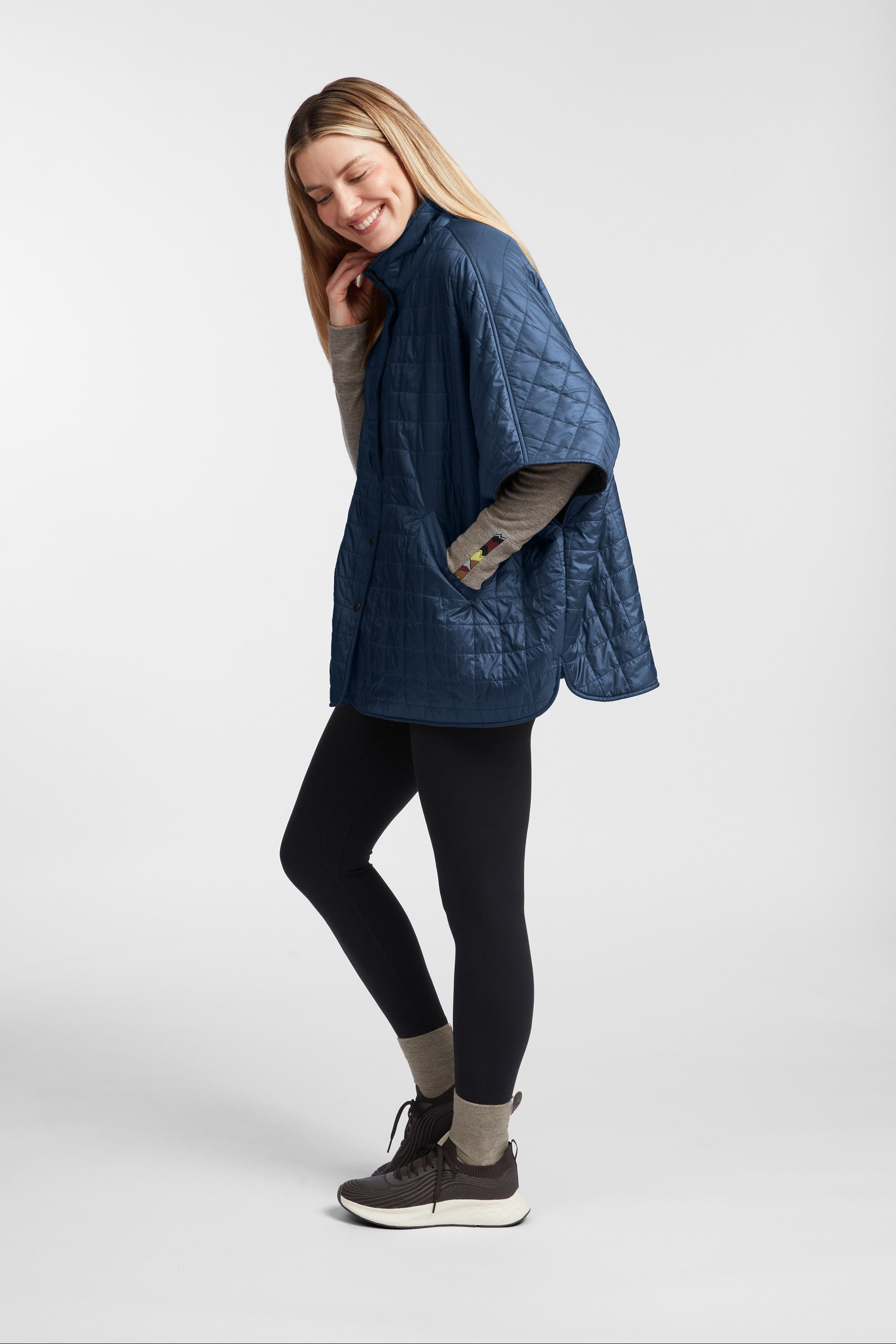Woman wearing a blue quilted jacket on a white background